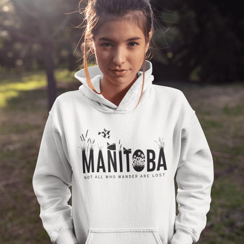 Featuring a serene prairie landscape, the design captures the essence of the heartland with wildflowers and prairie grasses growing out of the letters Manitoba.